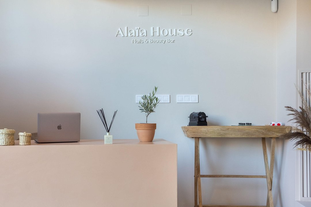 Recepción de Alaïa House con su rótulo original y mobiliario de madera